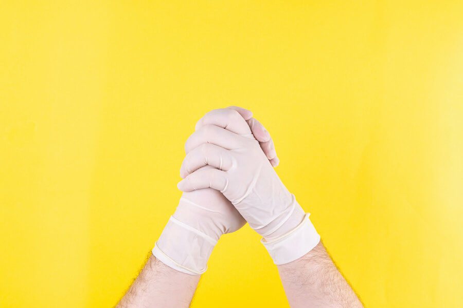 Hands clasping, wearing latex gloves