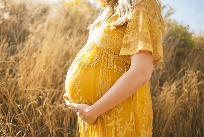 Pregnant woman in a sunny field