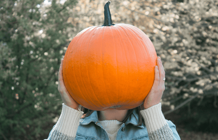 Woman holding a large pumpkin