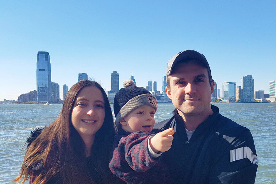 Simone Sherriff relaxing with her family by the water with a cityscape in the background.