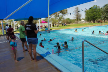 Children playing in Walgett Swimming pool as adults keep watch.