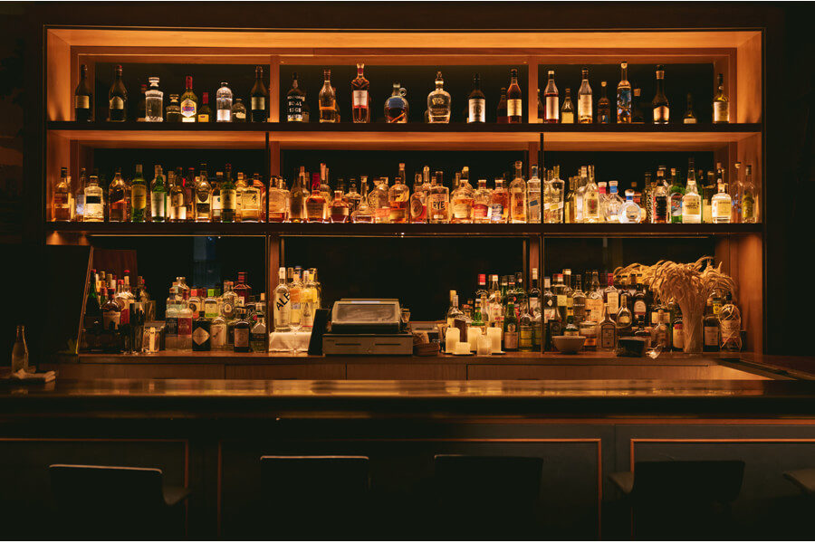 An empty bar with shelves of spirits