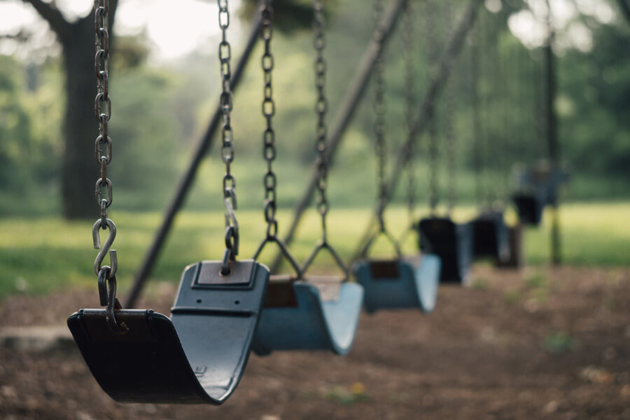 A row of empty swings in a playground