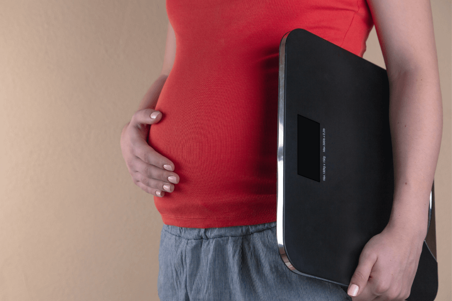 Pregnant woman holding a set of scales