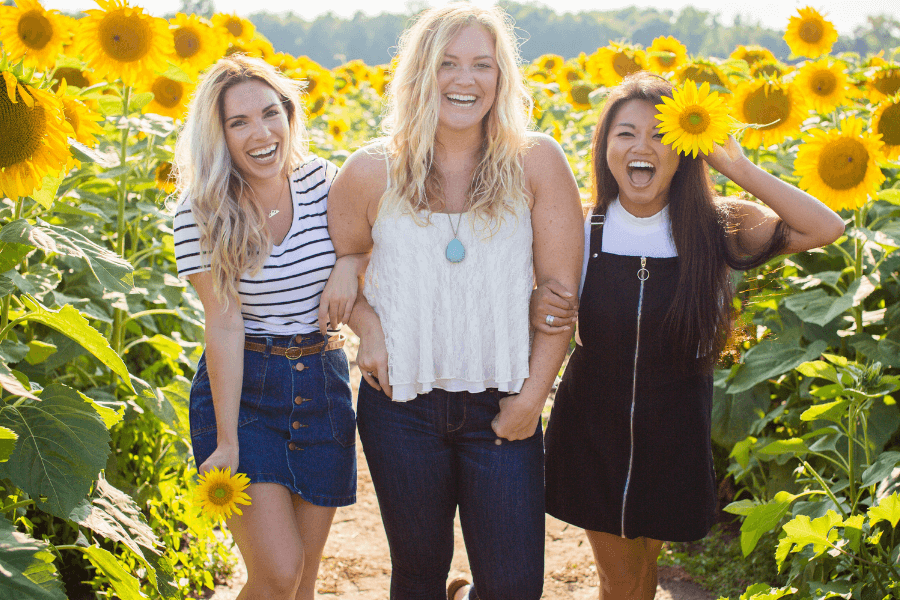 Three women in a field of sunflowers