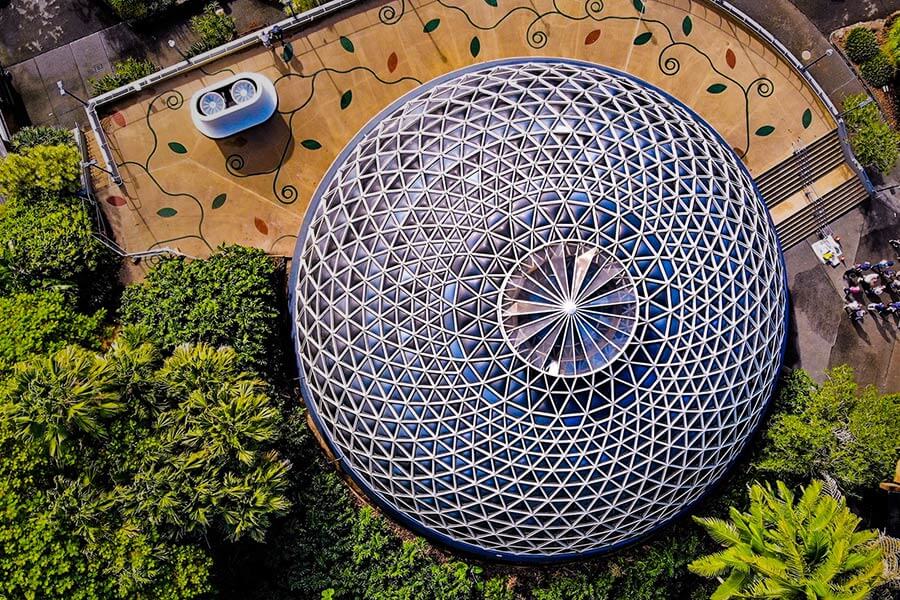 Aerial view of a giant glass dome at Mount Coot-tha Botanic Gardens, Queensland, Australia. Photo by Carles Rabada on Unsplash https://unsplash.com/photos/yziHs9xlnWk