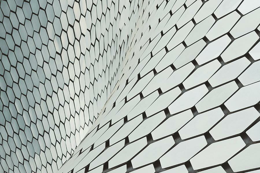 Detail of a sinuous, curving shape made of hexagons. Image by andrea leopardion Unsplash.