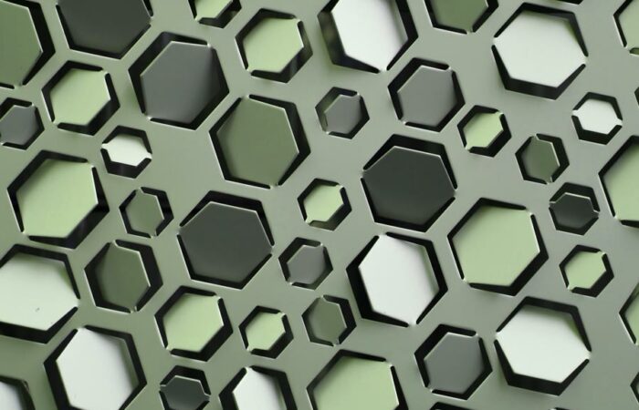 A sheet of metal with hexagonal flaps punched into it. Each flap is angled slightly differently. Image by aquaryus15 on Unsplash.
