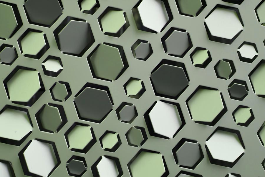 A sheet of metal with hexagonal flaps punched into it. Each flap is angled slightly differently. Image by aquaryus15 on Unsplash.