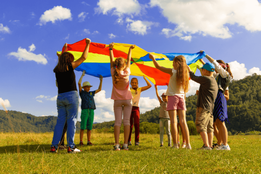 A group of children holding up a large kite