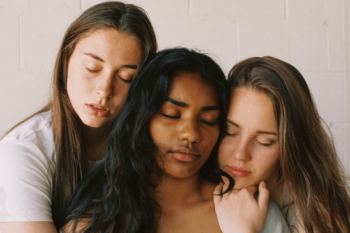 Three women hugging while closing their eyes