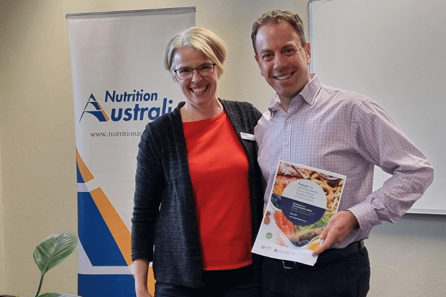 Gary Sacks holding a copy of Food Index Policy and standing next to Leanne Elliston