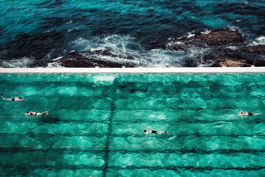 Swimmers in Bondi Icebergs pool with ocean in background