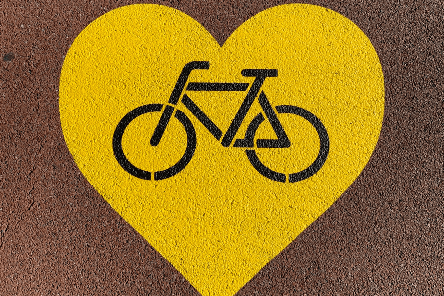 Bicycle sign inside a yellow heart on a path