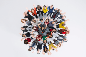 Aerial view of people in a circle looking up and waving