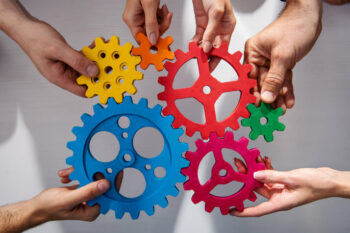 Hands holding cogs together to signify collaboration