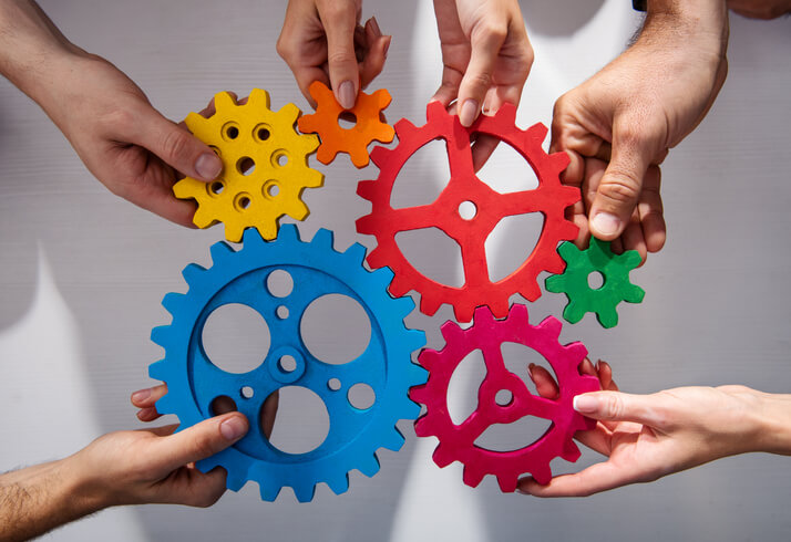Hands holding cogs together to signify collaboration