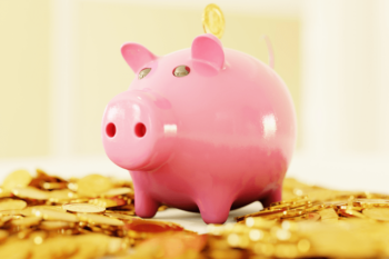 Pink piggy bank on top of gold coins