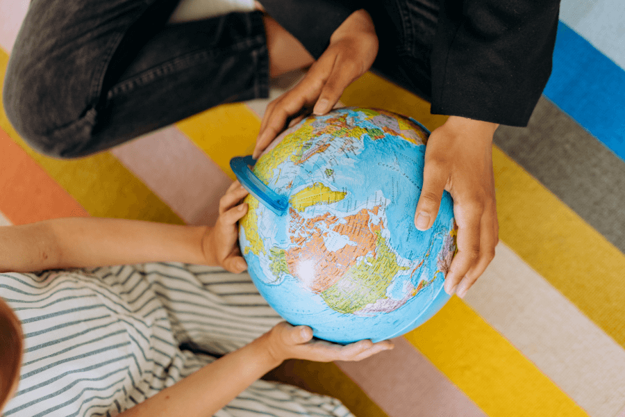 Child hands on a world globe