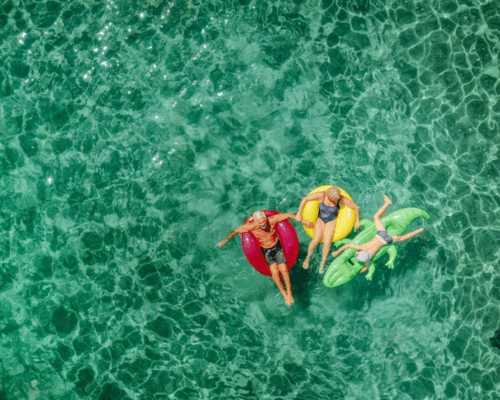 Aerial shot of people on floaties in a pool