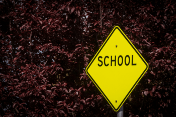 Yellow traffic sign with the word ;school'